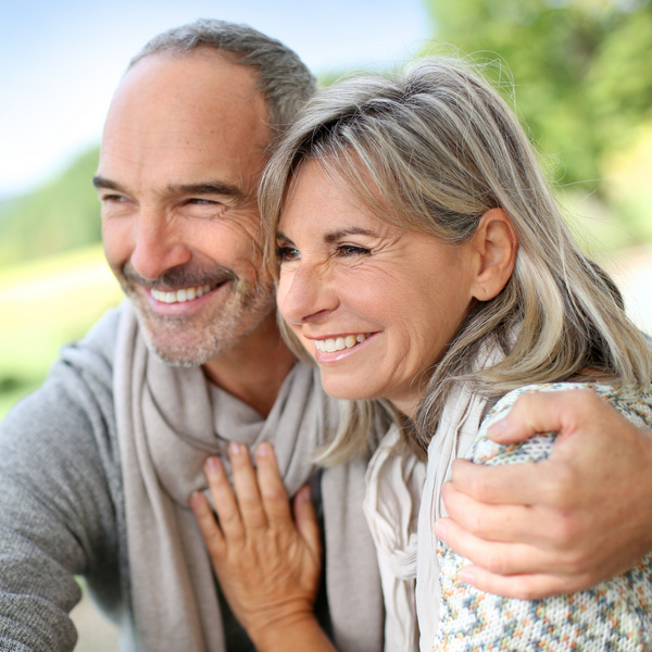 Portrait of loving senior couple hugging and smiling in a park