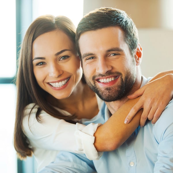 Man and woman are happily smiling and hugging